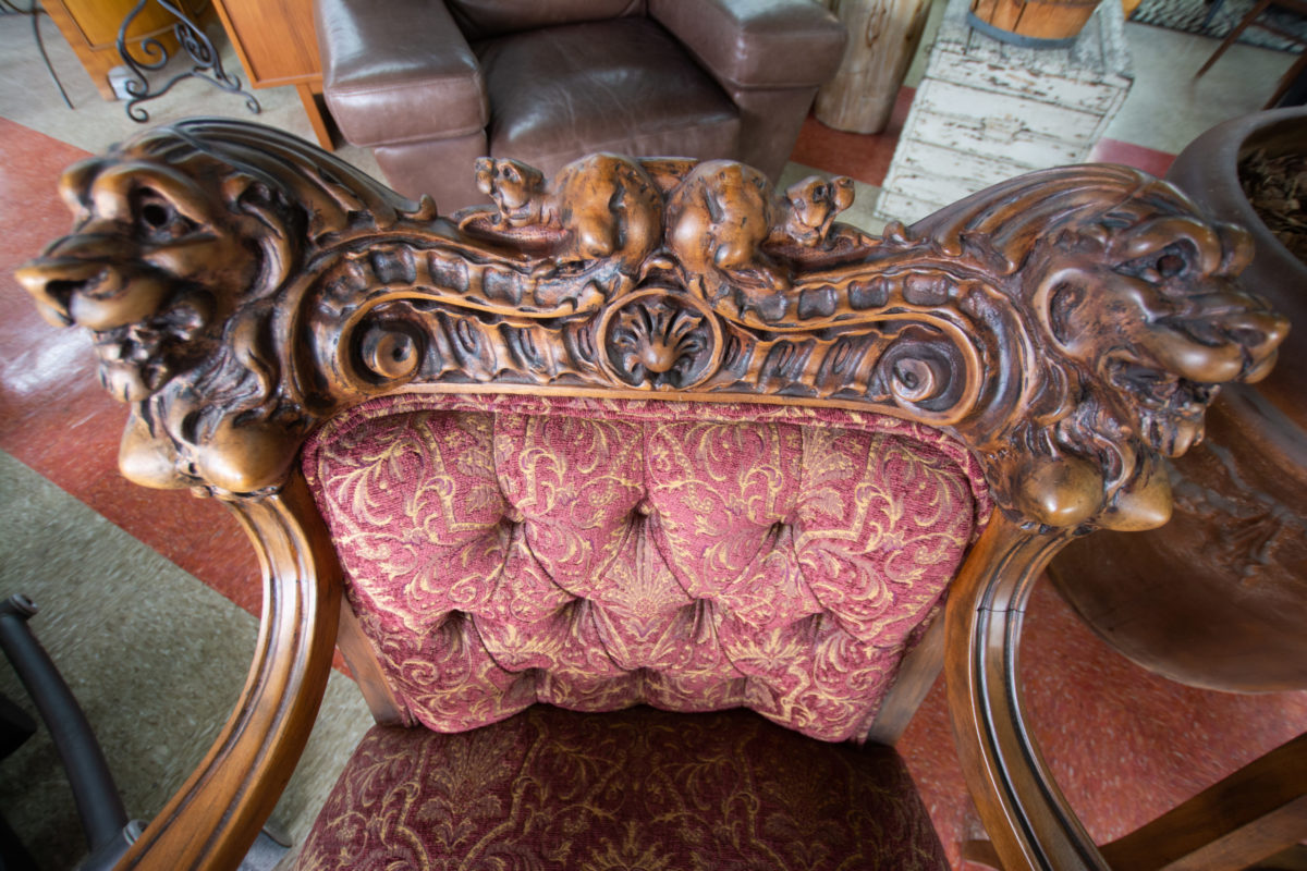 Vintage throne chair, featuring wood-carved lions and classic damask fabric.
